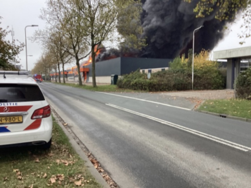 Politieauto staat bij de uitslaande brand