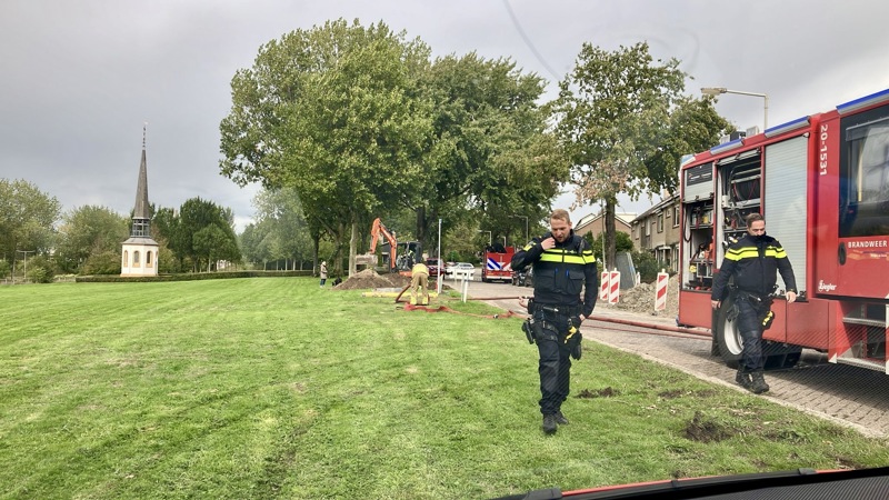 Politieagenten lopend naast een brandweervoertuig