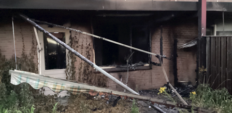 Woning met beneden en boven appartementen waarbij een benedenwoning kapot en zwart is door brand